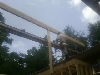 Carpenter setting a ridge beam over a new addition frame — Ice Dam Removal by Roofing Brothers in Summerville