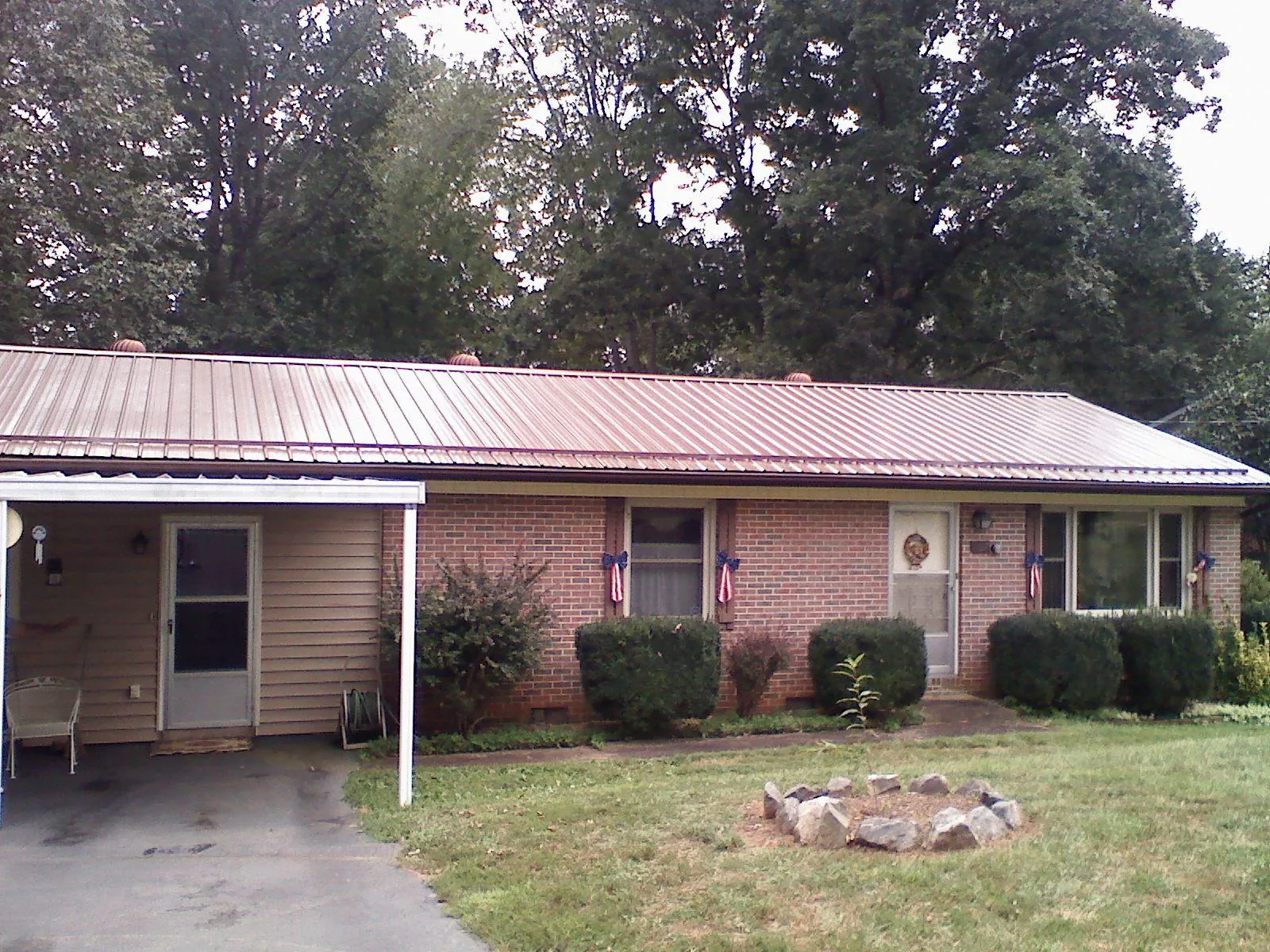 Bronze metal roof and carport on a brick ranch home — Roof Repair work by our crew in Summerville